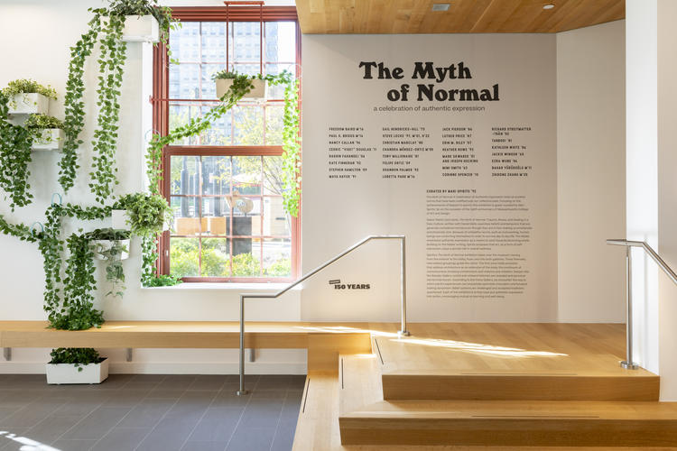 Sunny image of the MAAM lobby with the exhibition show title "They Myth of Normal" and hanging plants