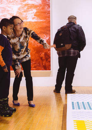 Director Lisa Tung points out artistic detail to a young student in the museum.